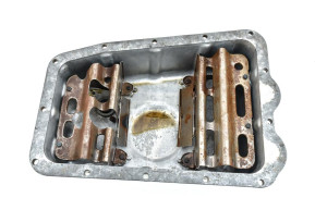 Oil pan with plug and partitions